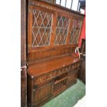 A 20th century oak dresser, outswept cornice above a pair of glazed doors enclosing a shelf,