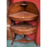 A George III mahogany bow-fronted corner washstand, drawer to frieze,