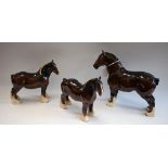 A Beswick model of a Shire horse, red ribbon; two others, smaller,