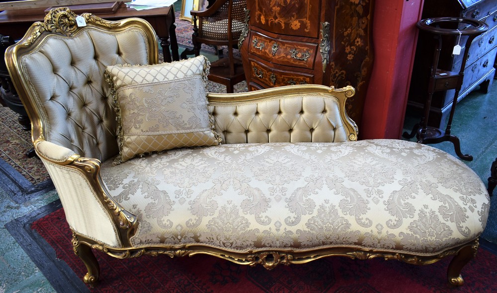 A Victorian design giltwood chaise lounge, stuffed over upholstery,