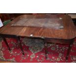 A George III mahogany D-end dining table, rounded rectangular top above a deep frieze, turned legs,