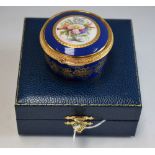 A Lynton porcelain circular table box, painted by Stefan Nowacki, signed, with a musical trophy,