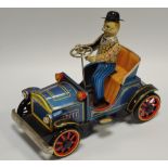 A tinplate motorised toy of a man driving an early 20th century car, made in Japan c.