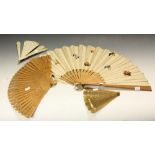 A late 19th century bone fan, intricate pierced decoration; a silk fan,