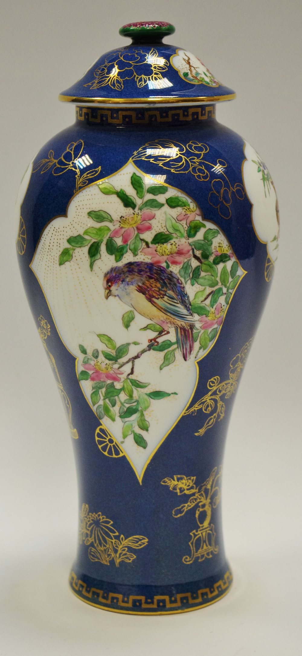 A Wedgwood slender inverted baluster vase and cover decorated with birds amongst flowering stems,