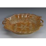A Brampton Derbyshire brown salt glazed stoneware shaped oval dish, moulded in relief with flowers,