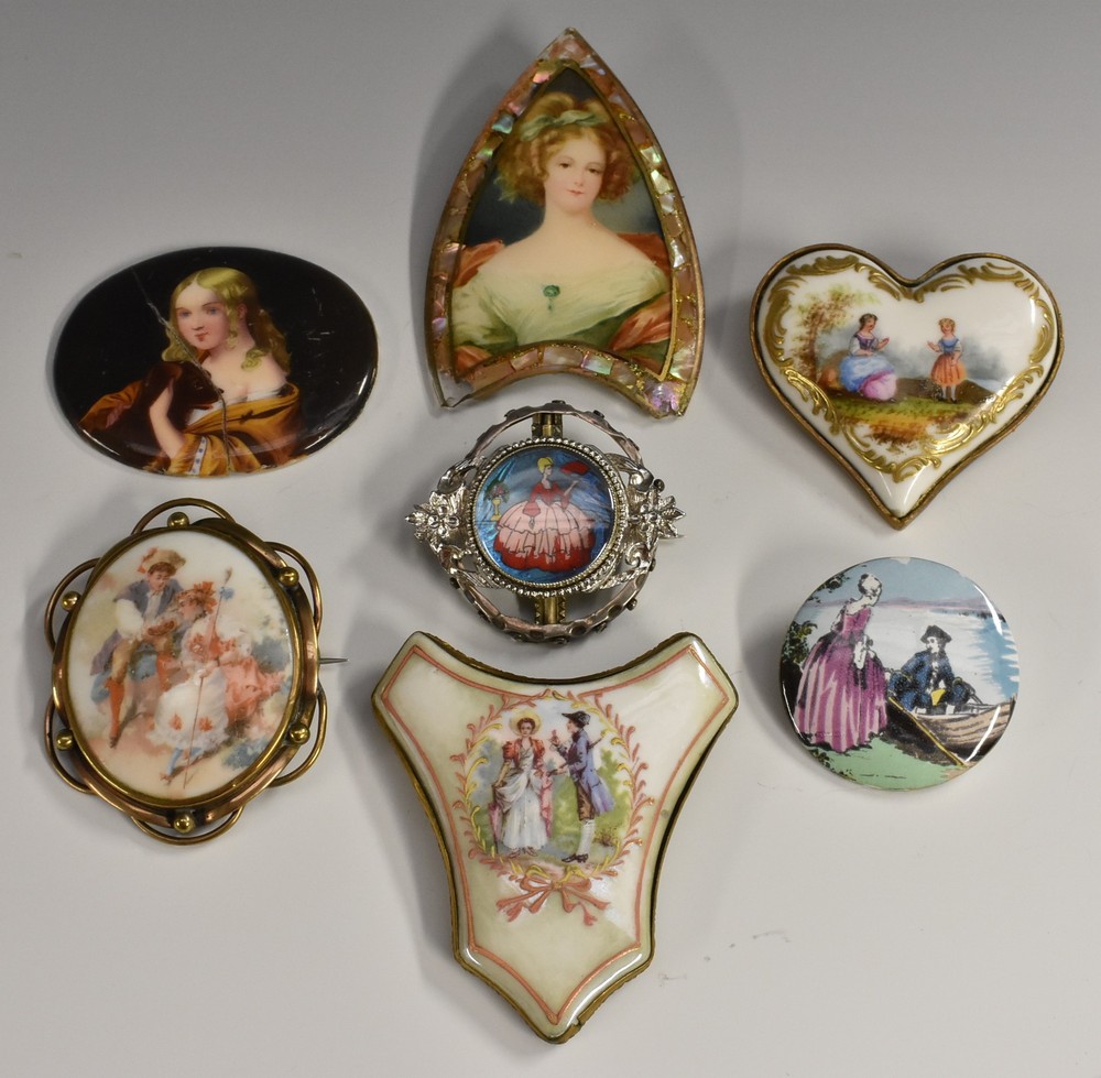 A late 19th century porcelain heart brooch, decorated with a seated lady and child within landscape,