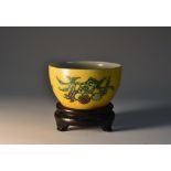 A Chinese wine cup, painted in tones of green, black and manganese with peaches and rip fruit,