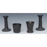 A pair of Wedgwood black basalt candlesticks, in relief with classical figures, leafy scrolls,