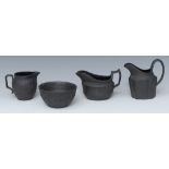 A Wedgwood black basalt cream jug and sugar bowl, in relief with scrolls, 7cm high,