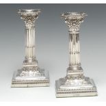 A pair of Edwardian silver stop-fluted Corinthian column candlesticks, of George III design,