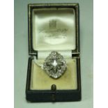 An Art Deco diamond star cluster ring, central cushion cut diamond approx 0.