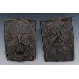 A near pair of 16th century oak gargoyles, carved with masks and foliage,