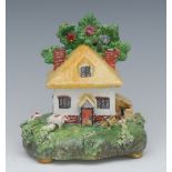 A Staffordshire pot pourri, in the form of a thatched cottage, before a tree, with pig sty, pigs,
