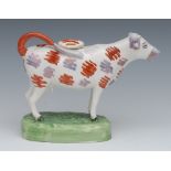 A 19th century Swansea cow creamer, standing four square, iron red, and lustre patch markings,