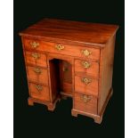 A George III mahogany kneehole desk, rounded rectangular top above a frieze drawer,