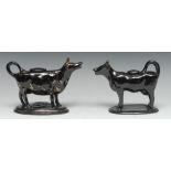 A Jackfield type cow creamer and cover, in black, picked out in gilt, oval base, 13cm high, c.