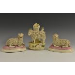 A pair of Staffordshire pottery models, of sheep, recumbent to left and right,