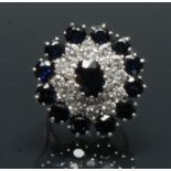 A sapphire and diamond cluster ring, central oval deep blue sapphire, measuring approx 8.33mm x 6.