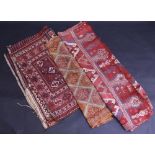 A pair of Turkish woven woollen rugs, in red, blue and cream, 205cm x 87cm; a wall hanging,