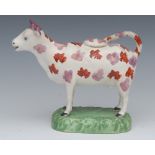 A 19th century Sunderland lustre cow creamer and cover, with pink and lustre markings, oval base,