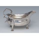 A George II silver sauce boat, with flying scroll handls, leafy pad feet, 12cm wide,