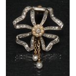 A diamond and seed pearl ribbon bow brooch, central round brilliant cut diamond,