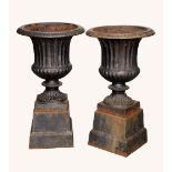 A pair of Victorian cast iron fluted campana garden urns, square bases, 47cm high, c.