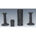 A pair of Wedgwood black basalt candlesticks, in relief with classical figures,