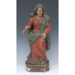 A North European polychrome and gesso softwood carving, of a saint, she stands, in cloak and robe,