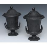 A pair of late 19th century Wedgwood black basalt two handled pedestal urnular vases and covers,