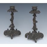 A pair of 19th century dark patinated candlesticks, cast throughout with fruiting vine, 22cm high,