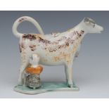 A 19th century cow creamer and cover, standing four square, with milkmaid, sponged in ochre and tan,