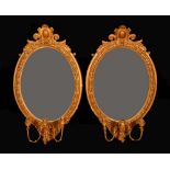 A pair of 19th century giltwood and gesso oval girandoles, each with cartouche shaped cresting,