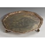 A George III style silver shaped circular salver, plain field, piecrust border,