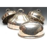 A graduated set of three Victorian EPNS fluted oval meat domes, lotus loop handles, the largest 46.