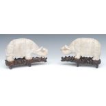 A pair of 19th century Chinese carved marble models of stylised elephants, with trunks raised,