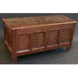 An 18th century oak coffer, hinged cover over later carved frieze and four carved panels,