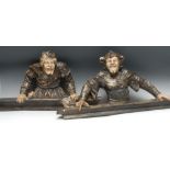 A pair of plaster door crestings, of medieval jesters, in buff and washed black,