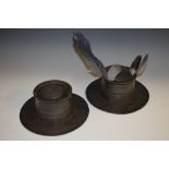 A pair of large 19th century pewter inkwells, each hinged cover within a band of pen apertures,