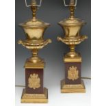 A pair of Regency style gilt brass and mahogany table lamps, each as a two-handled campana urn,