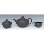 A Wedgwood three piece black basalt teapot, milk jug and sugar bowl,