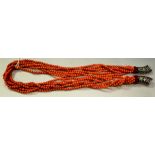 A coral bead necklace, six strands of interwoven entwined round red coral beads,