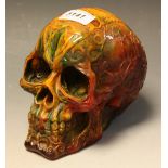 A cast resin amber coloured model of a skull,