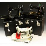 A Singer 222K Featherweight sewing machine, cased; two other cased Singer sewing machines,