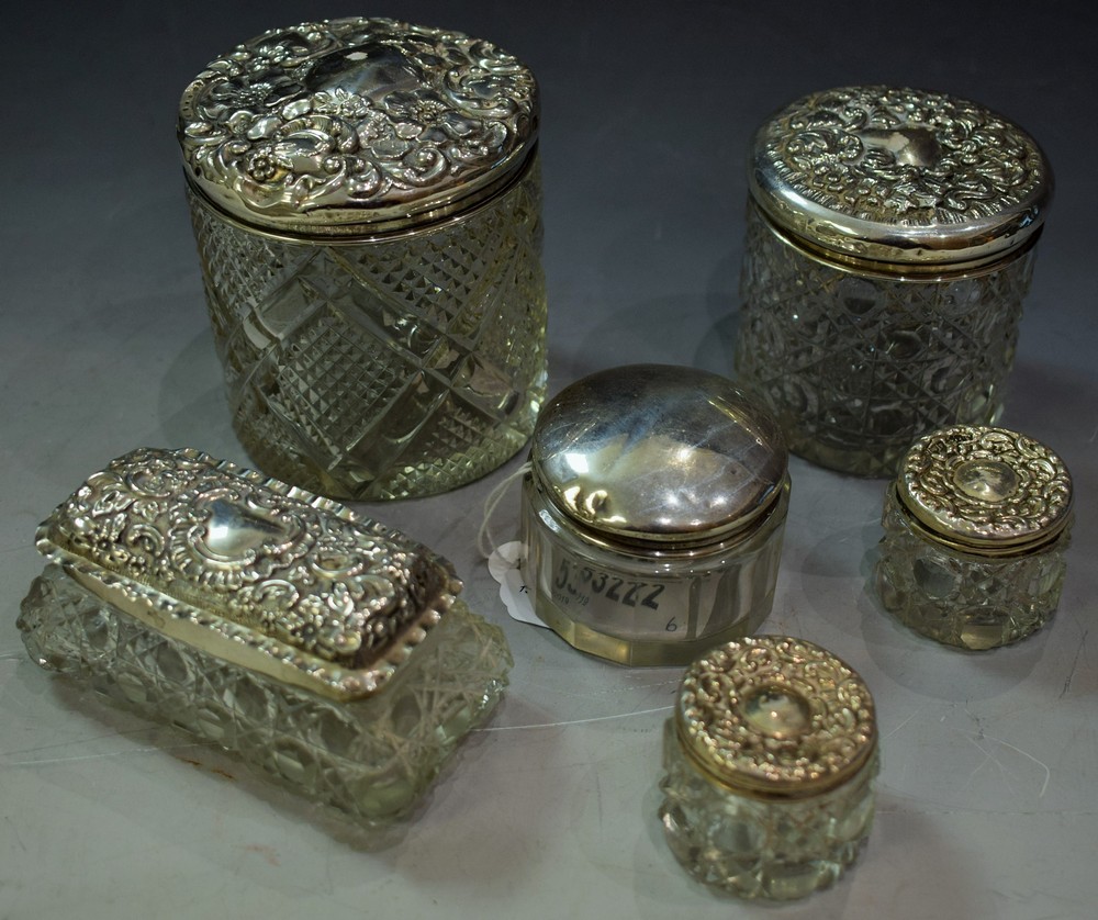 Silver topped cut glass dressing table jars with silver covers,