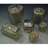 Silver topped cut glass dressing table jars with silver covers,