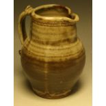 A Leach Pottery, St Ives ribbed ovoid water jug, scroll handle, glazed in shades of brown and grey,