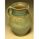 A stoneware ribbed ovoid jug, attributed to Richard Hamer, slip glazed in mottled blue, 21.