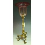 A brass table lamp, attributed to WS Benson, brass column, tripod feet, cranberry glass shade,